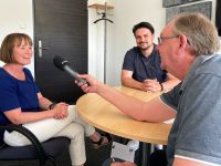 Evelyn Stegmann, Projektleiterin USIN5G beim Landkreis Harburg und Dr. Timo Maurer, Innovationsmanager bei der WLH Wirtschaftsförderung im Landkreis Harburg GmbH im Gespräch mit Wolfgang Laudan von Radio Zusa. Foto: WLH / Bianca Augustin